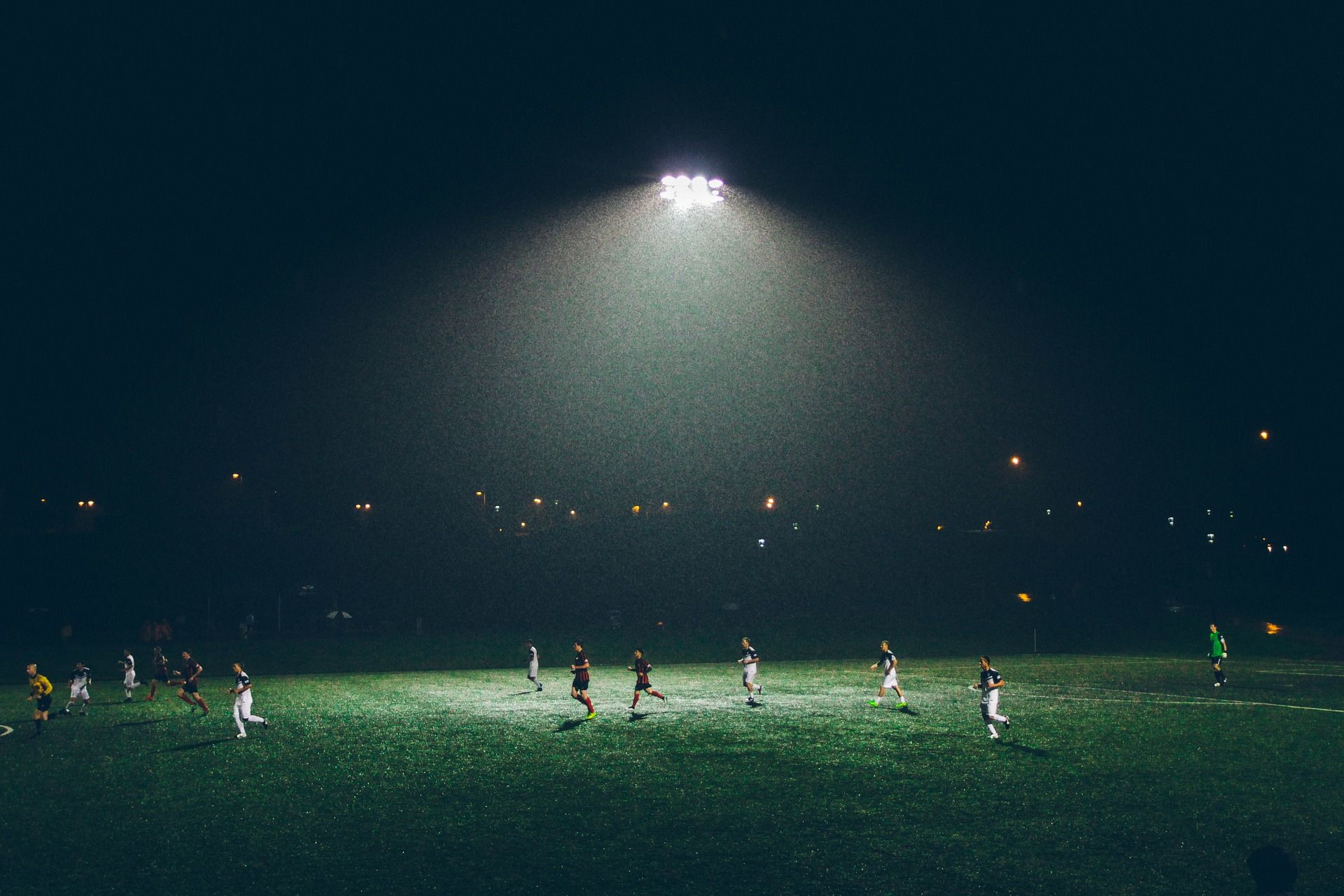 Soccer players on a field at night